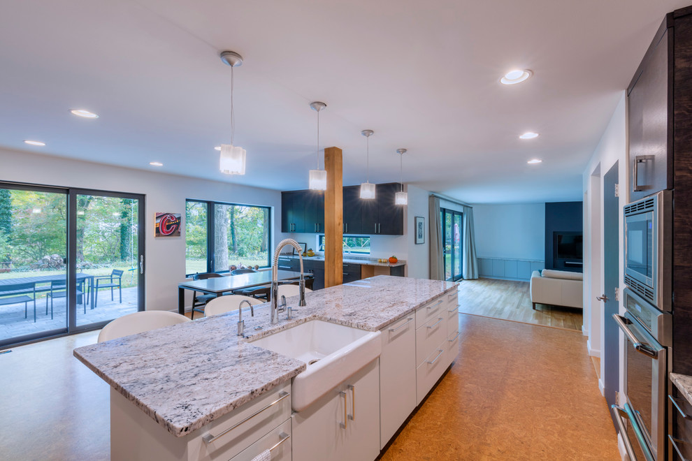 Eat-in kitchen - mid-sized contemporary l-shaped cork floor and brown floor eat-in kitchen idea in Columbus with a farmhouse sink, flat-panel cabinets, dark wood cabinets, granite countertops, stainless steel appliances and an island