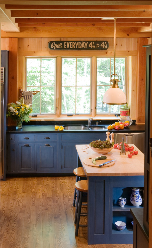 Exempel på ett avskilt, mellanstort amerikanskt u-kök, med en dubbel diskho, skåp i shakerstil, blå skåp, bänkskiva i täljsten, flerfärgad stänkskydd, stänkskydd i stenkakel, rostfria vitvaror, mellanmörkt trägolv och en köksö