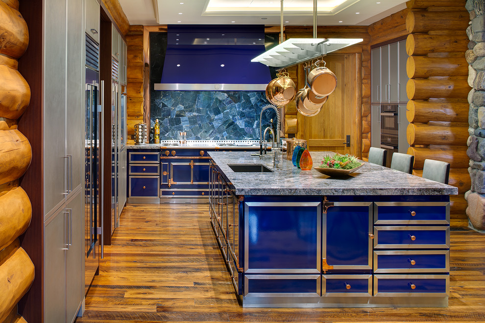 Große Urige Küche mit Unterbauwaschbecken, flächenbündigen Schrankfronten, Granit-Arbeitsplatte, braunem Holzboden, Kücheninsel, grauen Schränken, Küchenrückwand in Blau, bunten Elektrogeräten und blauer Arbeitsplatte in Sonstige