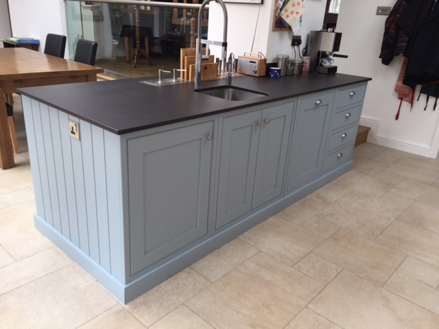 Large classic galley open plan kitchen in Other with a submerged sink, shaker cabinets, blue cabinets, engineered stone countertops, black splashback, black appliances and an island.