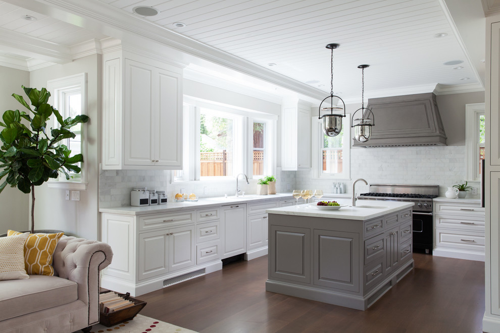 Inspiration for a timeless u-shaped dark wood floor open concept kitchen remodel in San Francisco with white cabinets, marble countertops, white backsplash, black appliances, an island and raised-panel cabinets