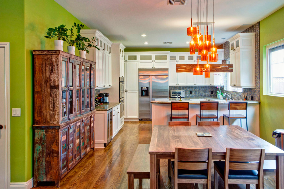 Moderne Wohnküche in U-Form mit weißen Schränken, Rückwand aus Mosaikfliesen, Küchengeräten aus Edelstahl und braunem Holzboden in San Diego