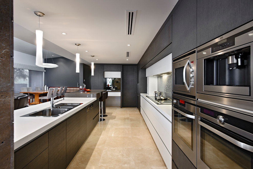 Источник вдохновения для домашнего уюта: угловая кухня-гостиная в современном стиле с накладной мойкой, плоскими фасадами и темными деревянными фасадами