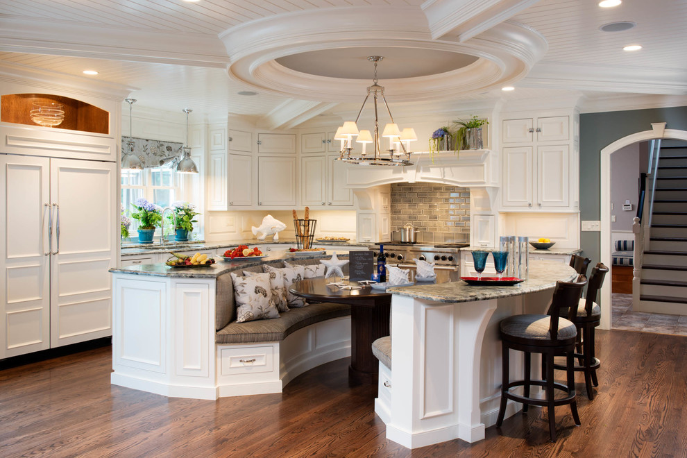 Elegant l-shaped eat-in kitchen photo in Manchester with white cabinets and two islands