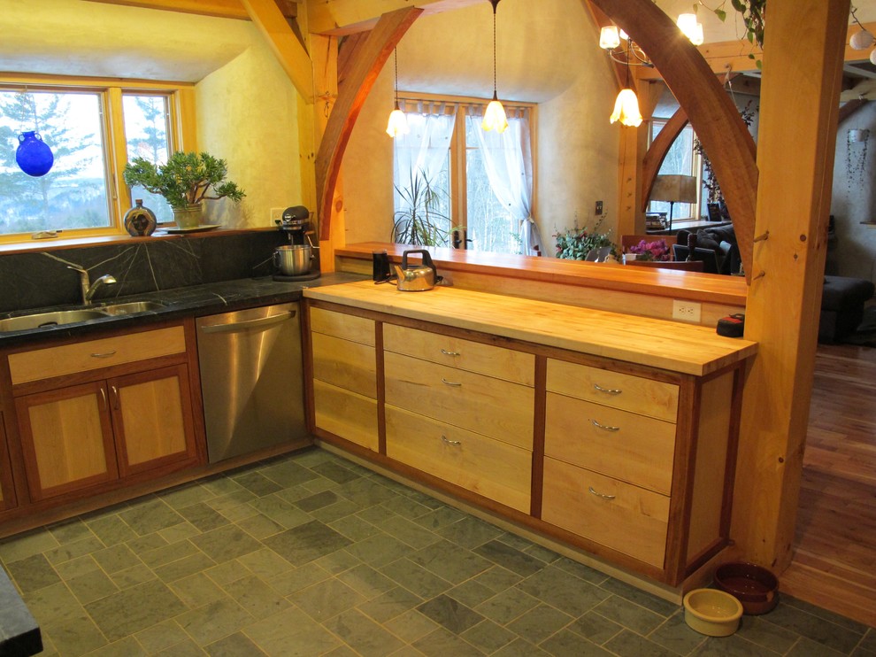 Inredning av ett amerikanskt mellanstort kök och matrum, med en dubbel diskho, luckor med infälld panel, skåp i ljust trä, bänkskiva i täljsten, grått stänkskydd, stänkskydd i sten, rostfria vitvaror, skiffergolv, en halv köksö och grönt golv