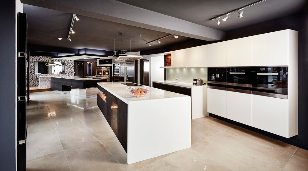 Exempel på ett mycket stort modernt kök med öppen planlösning, med en nedsänkt diskho, släta luckor, vita skåp, bänkskiva i kvartsit, vitt stänkskydd, stänkskydd i glaskakel, rostfria vitvaror och en köksö