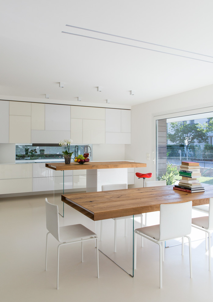 Modelo de cocina comedor moderna de tamaño medio con armarios con paneles lisos, puertas de armario blancas, encimera de madera, salpicadero con efecto espejo, suelo blanco, fregadero bajoencimera y una isla