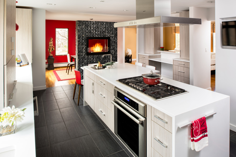 Foto på ett mellanstort funkis kök, med en undermonterad diskho, släta luckor, rostfria vitvaror, en köksö, skåp i ljust trä, klinkergolv i porslin och grått golv