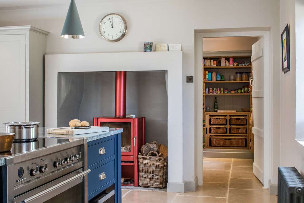 Küche mit Landhausspüle, Schrankfronten im Shaker-Stil, blauen Schränken, Granit-Arbeitsplatte, Küchengeräten aus Edelstahl, Kalkstein, Kücheninsel, beigem Boden und grauer Arbeitsplatte in Wiltshire