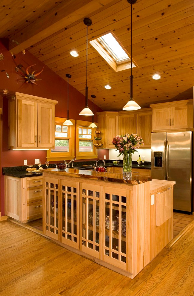 This is an example of a large bohemian l-shaped kitchen/diner in Santa Barbara with a submerged sink, recessed-panel cabinets, light wood cabinets, granite worktops, stainless steel appliances, terracotta flooring and an island.
