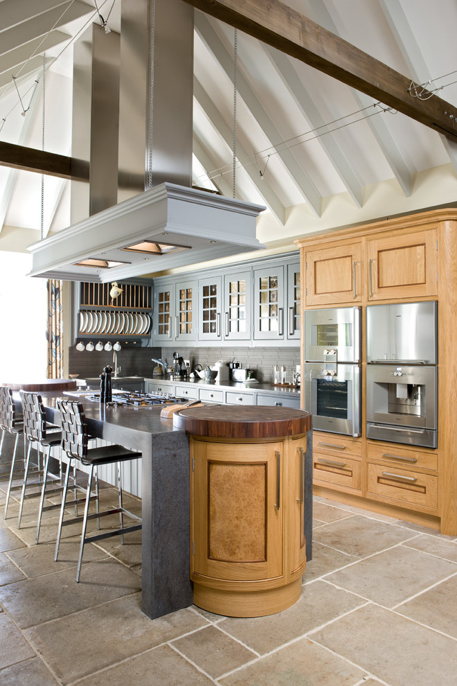 Foto di una cucina chic di medie dimensioni con paraspruzzi grigio, elettrodomestici in acciaio inossidabile, pavimento in pietra calcarea e ante grigie