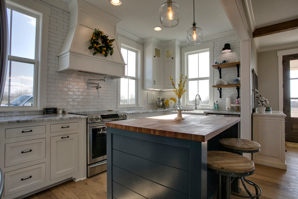 Idéer för att renovera ett stort lantligt kök, med en rustik diskho, skåp i shakerstil, vita skåp, marmorbänkskiva, vitt stänkskydd, stänkskydd i tunnelbanekakel, rostfria vitvaror, mellanmörkt trägolv, en köksö och brunt golv