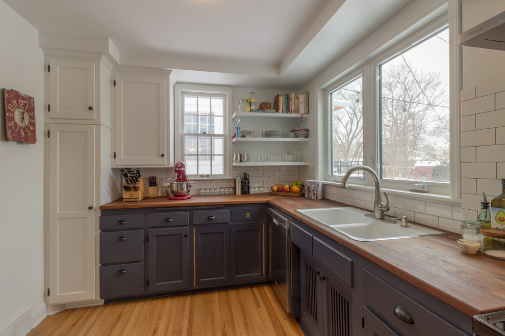 Inspiration for a large scandinavian l-shaped medium tone wood floor and brown floor open concept kitchen remodel in Minneapolis with a double-bowl sink, recessed-panel cabinets, blue cabinets, wood countertops, white backsplash, subway tile backsplash, stainless steel appliances and a peninsula
