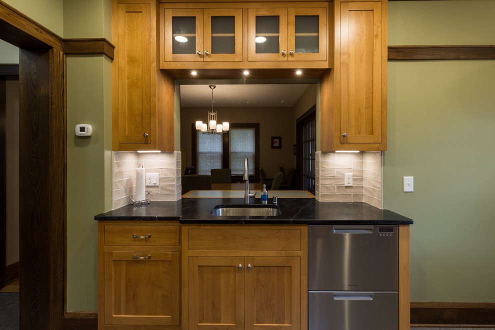 Design ideas for a traditional kitchen in Minneapolis with a submerged sink, flat-panel cabinets, medium wood cabinets, soapstone worktops, beige splashback, stainless steel appliances, lino flooring, no island and beige floors.