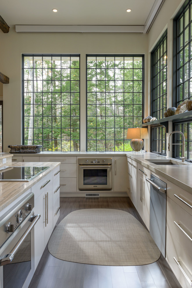Transitional l-shaped kitchen photo in Manchester with flat-panel cabinets, beige cabinets and an island