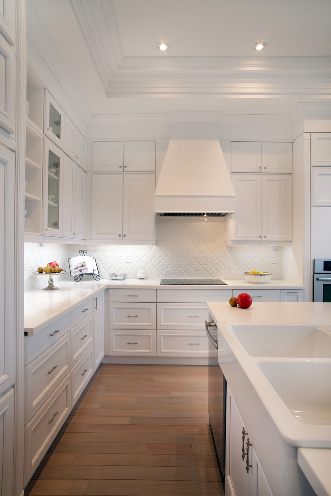 На фото: кухня в классическом стиле с белыми фасадами и белым фартуком с