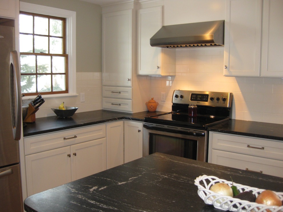 Inspiration för ett vintage svart svart kök, med en undermonterad diskho, skåp i shakerstil, vita skåp, bänkskiva i kvarts, vitt stänkskydd, stänkskydd i keramik, rostfria vitvaror, mellanmörkt trägolv och en köksö