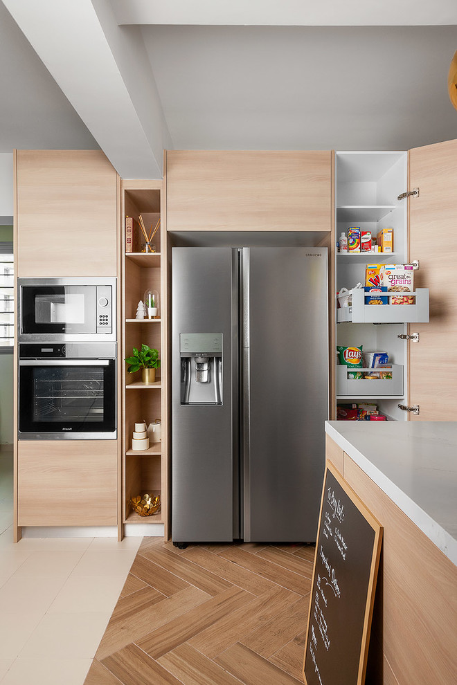 Imagen de cocina actual con armarios con paneles lisos, puertas de armario de madera clara, electrodomésticos de acero inoxidable y suelo de madera clara