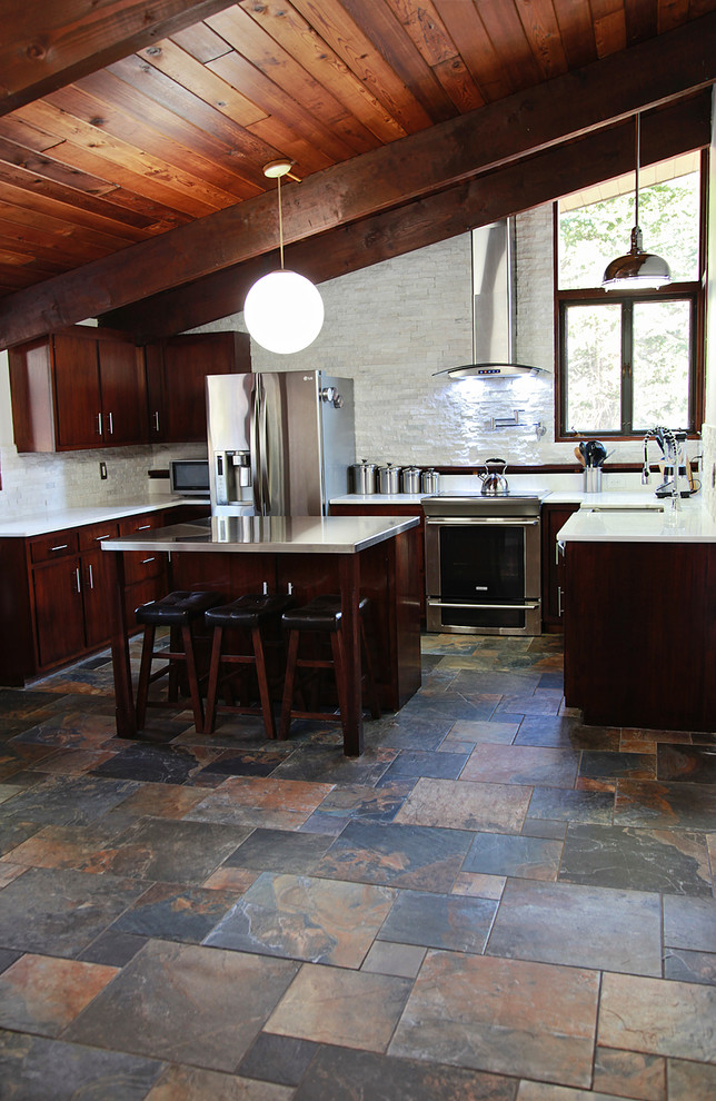 Immagine di una grande cucina ad U tradizionale con elettrodomestici in acciaio inossidabile e pavimento in gres porcellanato