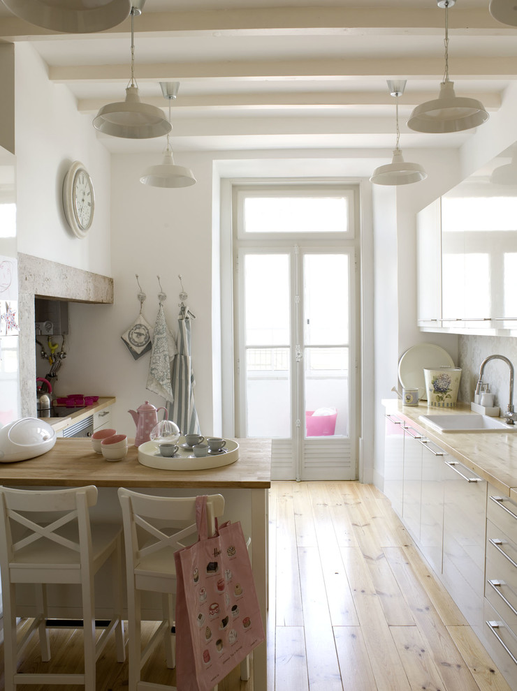Diseño de cocina clásica renovada con fregadero encastrado, armarios con paneles lisos, puertas de armario blancas y encimera de madera