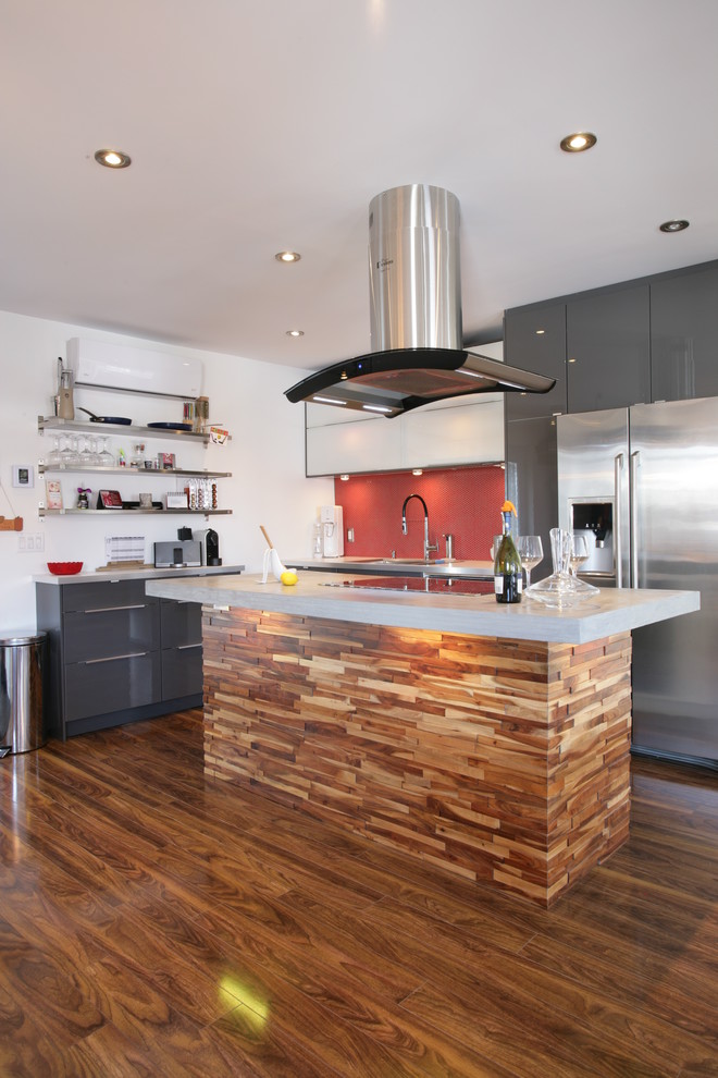 Moderne Küche in L-Form mit flächenbündigen Schrankfronten, grauen Schränken, Küchenrückwand in Rot, Glasrückwand und Küchengeräten aus Edelstahl in Montreal