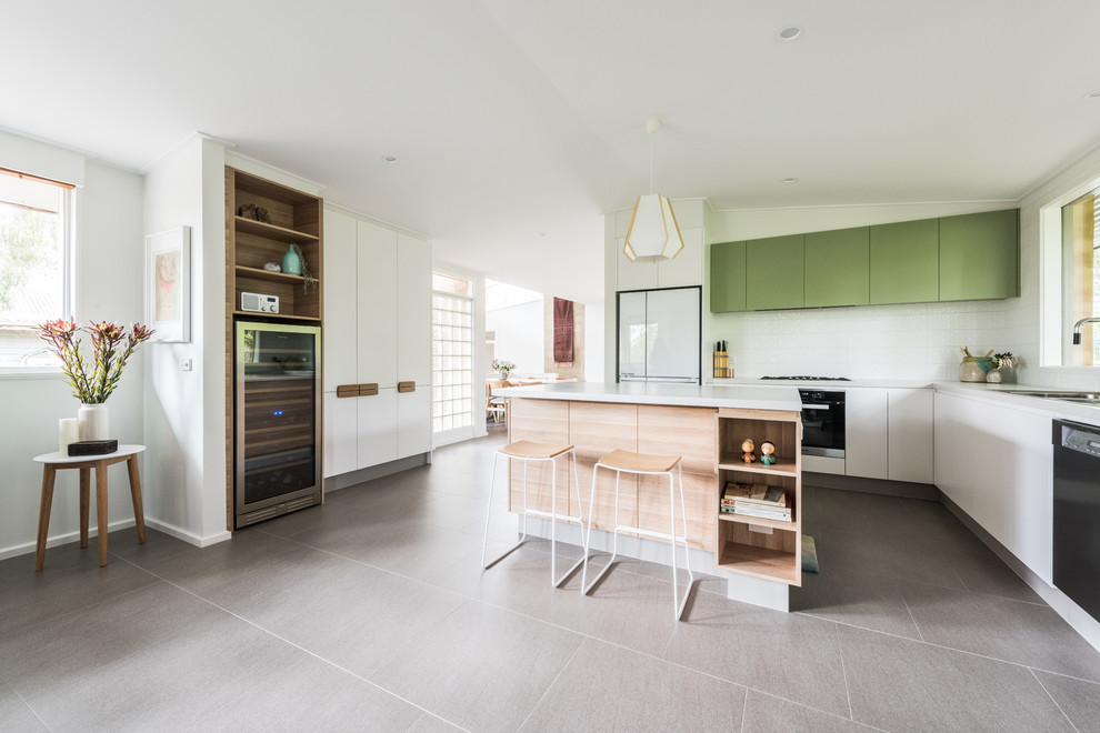 Inspiration for a medium sized scandinavian u-shaped open plan kitchen in Melbourne with green cabinets, engineered stone countertops, white splashback, ceramic splashback, stainless steel appliances, porcelain flooring, an island, grey floors and grey worktops.