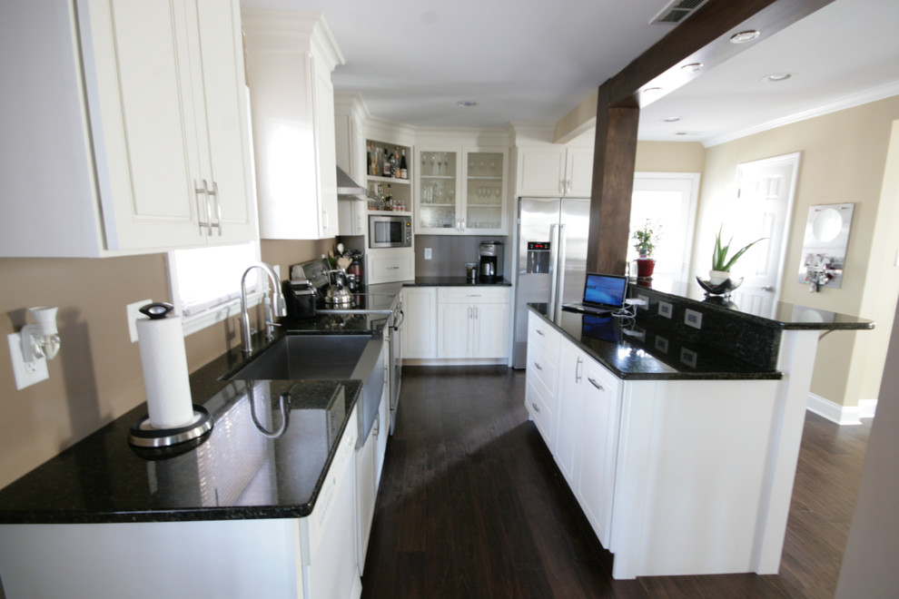 Immagine di una cucina chic di medie dimensioni con lavello stile country, ante con bugna sagomata, ante bianche, elettrodomestici in acciaio inossidabile e parquet scuro