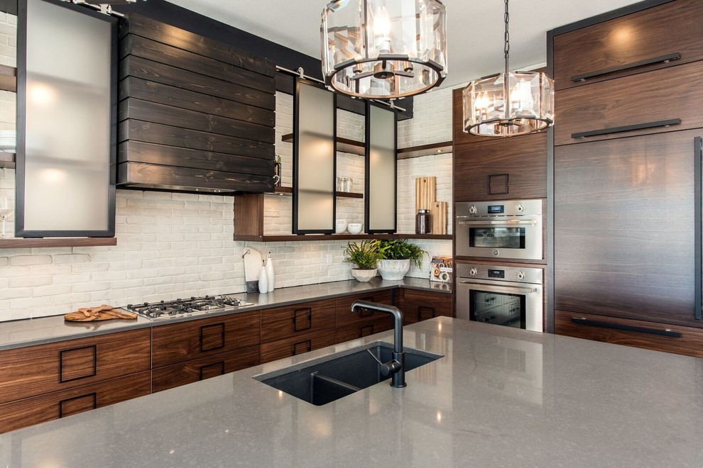 Eat-in kitchen - large industrial l-shaped eat-in kitchen idea in Other with an undermount sink, flat-panel cabinets, dark wood cabinets, quartz countertops, white backsplash, brick backsplash, paneled appliances and an island