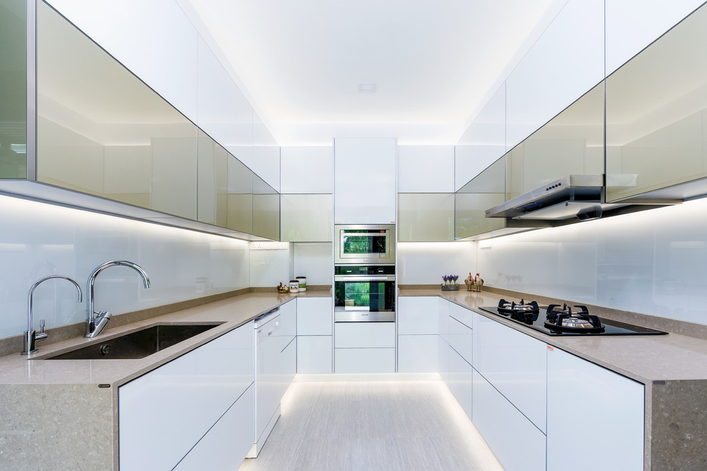Idee per una cucina moderna di medie dimensioni con lavello sottopiano, ante lisce, elettrodomestici in acciaio inossidabile e nessuna isola