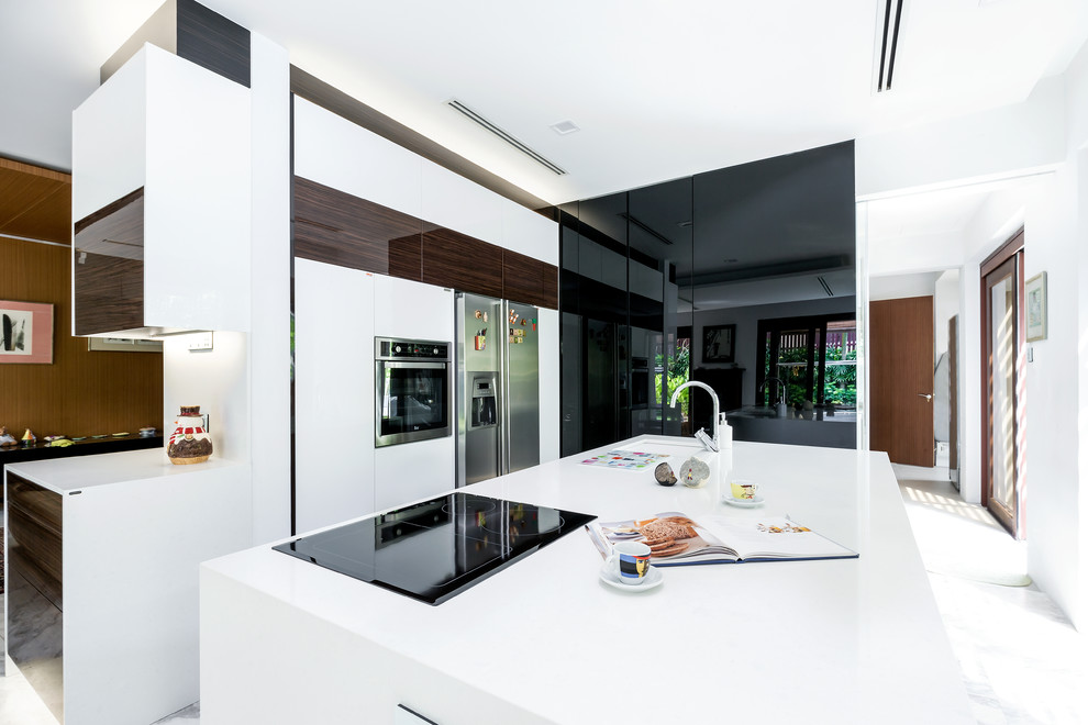 Bild på ett stort funkis kök, med en undermonterad diskho, rostfria vitvaror, en köksö och släta luckor
