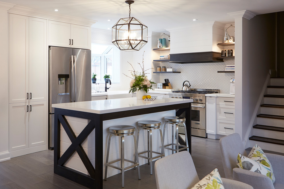 Example of a cottage dark wood floor and brown floor eat-in kitchen design in Toronto with a farmhouse sink, white cabinets, quartz countertops, white backsplash, ceramic backsplash, stainless steel appliances, an island and white countertops