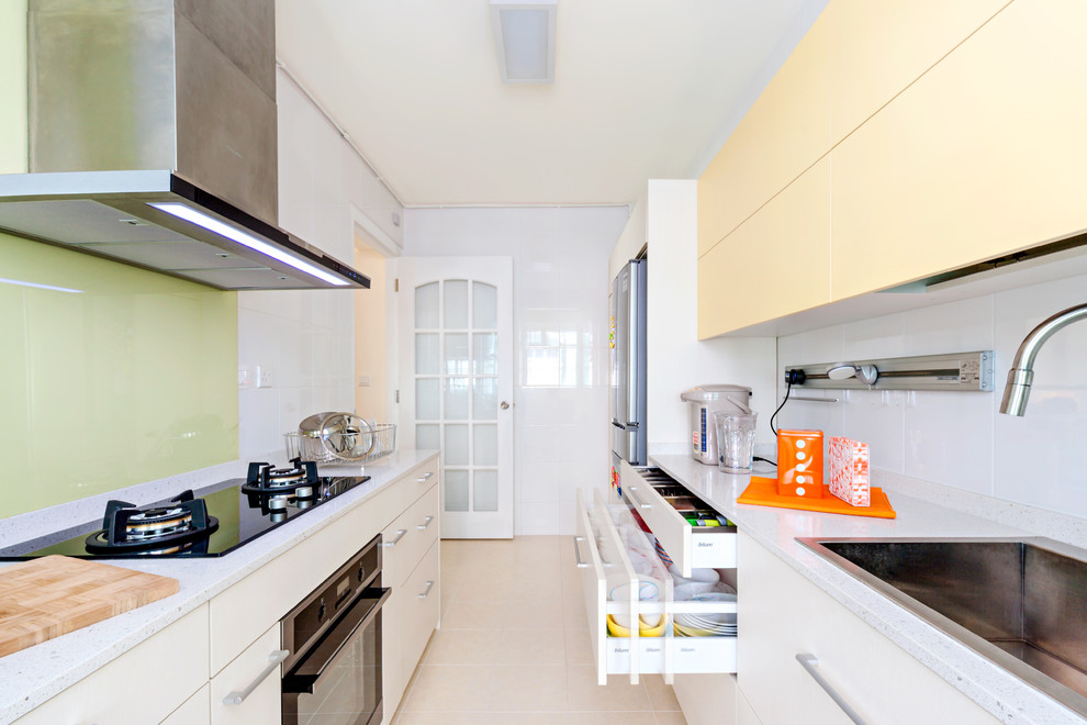 Bild på ett litet funkis kök, med en undermonterad diskho, släta luckor, gula skåp och rostfria vitvaror