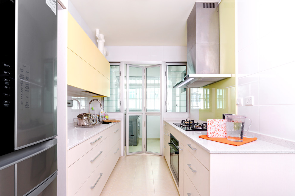 Diseño de cocina comedor moderna pequeña sin isla con fregadero bajoencimera, puertas de armario amarillas y electrodomésticos de acero inoxidable