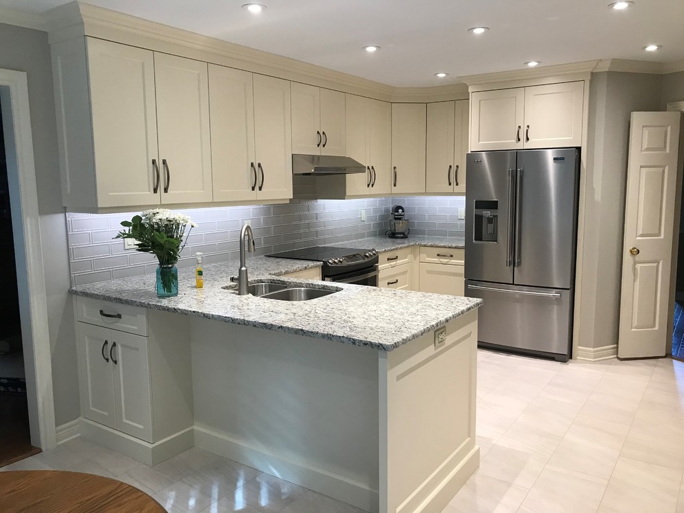 Example of a mid-sized transitional u-shaped porcelain tile and beige floor enclosed kitchen design in Toronto with an undermount sink, shaker cabinets, beige cabinets, granite countertops, gray backsplash, porcelain backsplash, a peninsula and gray countertops