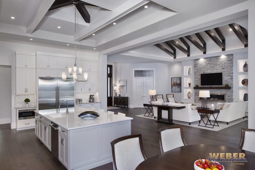 Photo of a large contemporary open plan kitchen in Miami with recessed-panel cabinets, white cabinets, grey splashback, stainless steel appliances, dark hardwood flooring, an island and brown floors.