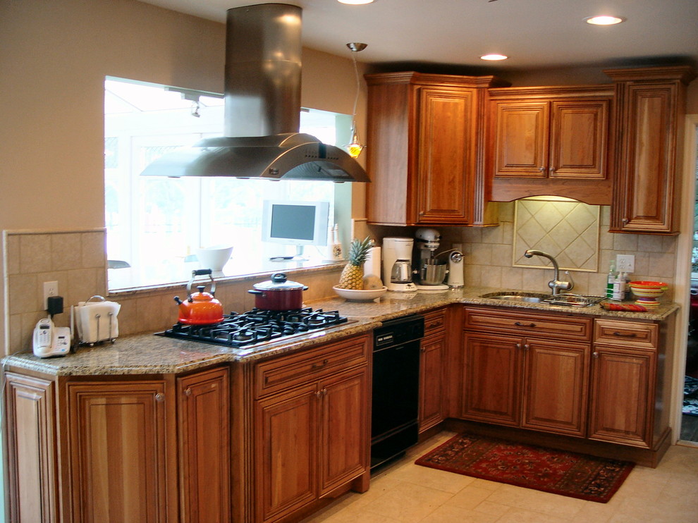 Klassisk inredning av ett mellanstort l-kök, med en dubbel diskho, luckor med upphöjd panel, skåp i mörkt trä, granitbänkskiva, beige stänkskydd, stänkskydd i keramik, rostfria vitvaror och klinkergolv i keramik