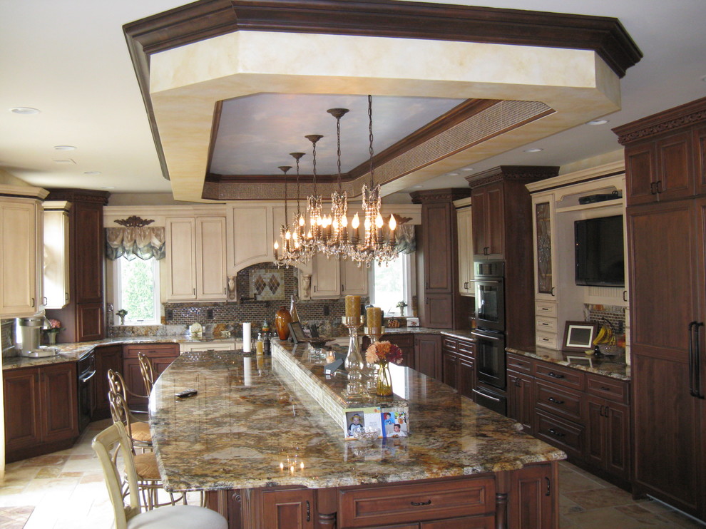 Inspiration for a mid-sized mediterranean u-shaped ceramic tile kitchen remodel in New York with an undermount sink, recessed-panel cabinets, dark wood cabinets, granite countertops, multicolored backsplash, mosaic tile backsplash, black appliances and an island