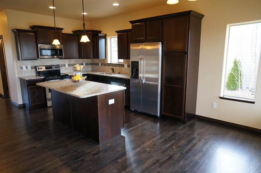 Example of a transitional dark wood floor eat-in kitchen design in Denver with recessed-panel cabinets, dark wood cabinets, stainless steel appliances and an island