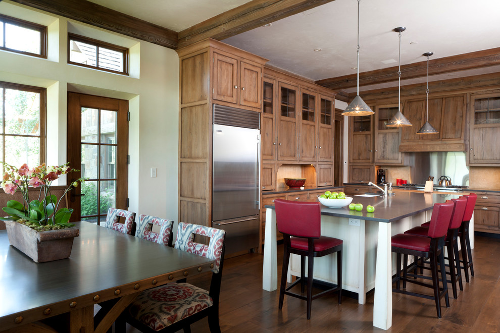 Foto på ett stort rustikt kök, med en undermonterad diskho, luckor med infälld panel, rostfria vitvaror, mellanmörkt trägolv, en köksö, skåp i mellenmörkt trä, beige stänkskydd och bänkskiva i koppar