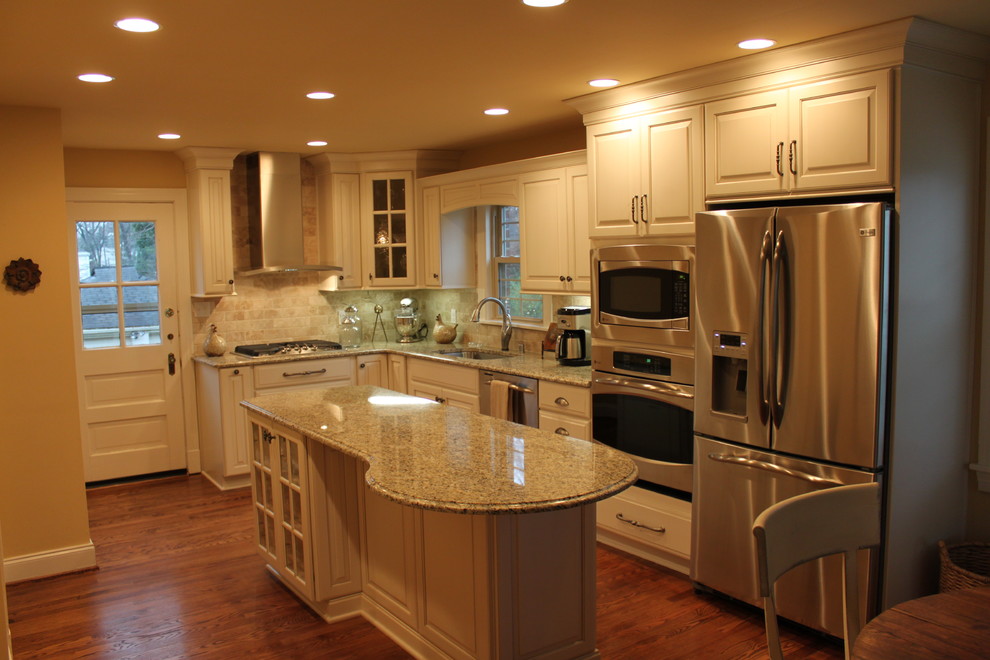 This is an example of a classic l-shaped kitchen/diner in Louisville with a submerged sink, raised-panel cabinets, beige cabinets and stainless steel appliances.