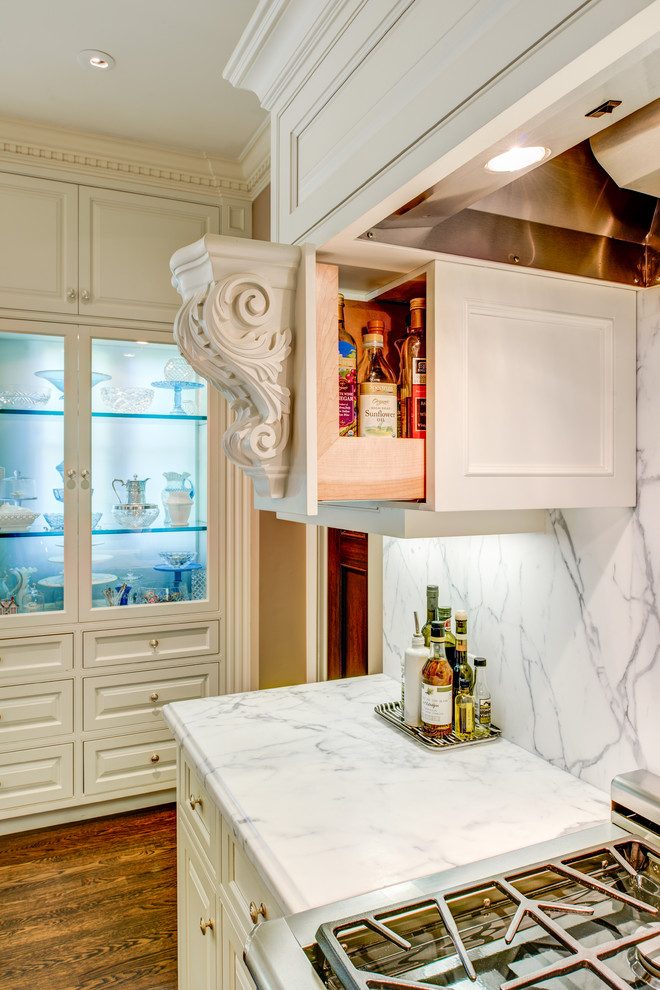 Modelo de cocina clásica con puertas de armario blancas, salpicadero blanco, salpicadero de mármol, suelo marrón y suelo de madera oscura