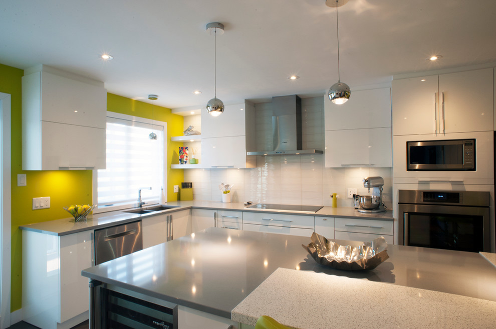 Immagine di una cucina moderna con lavello a doppia vasca, ante lisce, ante bianche, top in quarzite, paraspruzzi bianco, paraspruzzi con piastrelle di vetro e elettrodomestici in acciaio inossidabile