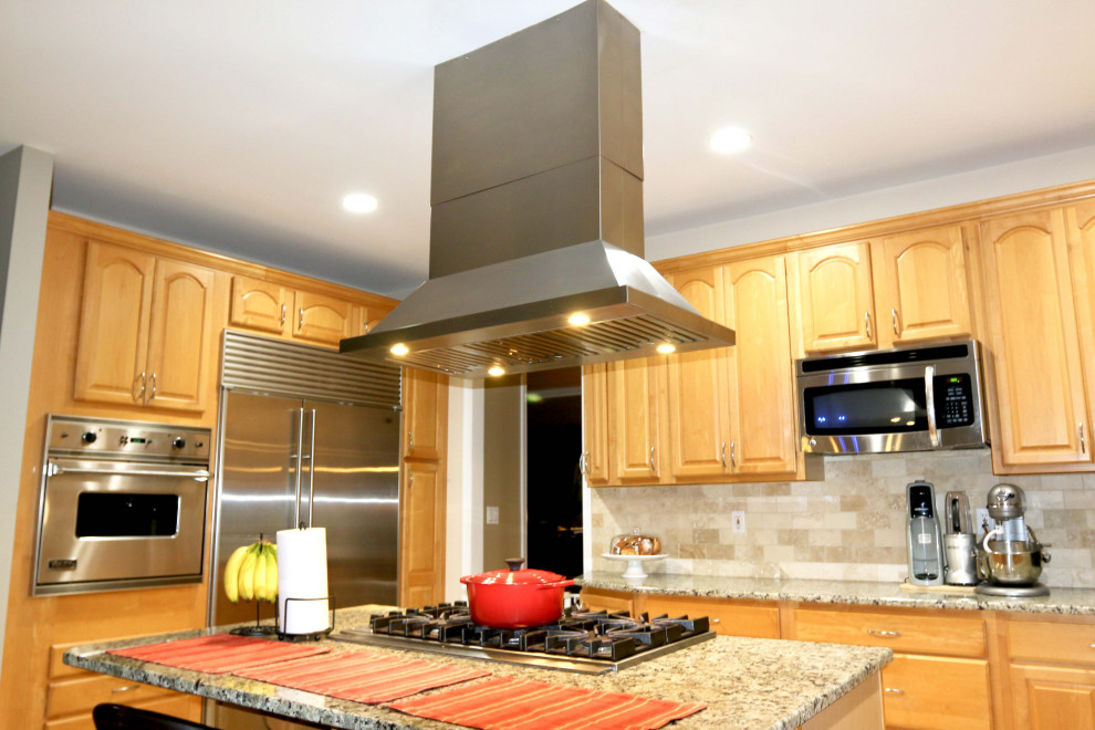 Foto di una cucina minimalista di medie dimensioni con ante con riquadro incassato, ante beige, top in granito, paraspruzzi bianco, paraspruzzi con piastrelle di cemento, elettrodomestici in acciaio inossidabile e top marrone
