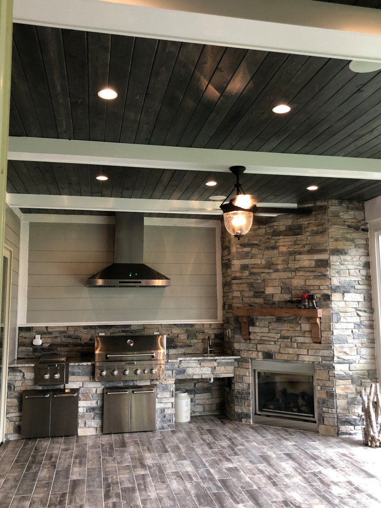 Foto di una cucina design di medie dimensioni con paraspruzzi beige, paraspruzzi in legno, elettrodomestici in acciaio inossidabile, pavimento in cementine e pavimento marrone