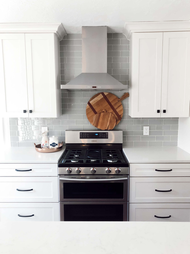 Esempio di una cucina moderna di medie dimensioni con ante in stile shaker, ante bianche, top in laminato, paraspruzzi grigio, paraspruzzi con piastrelle in ceramica, elettrodomestici in acciaio inossidabile e top bianco
