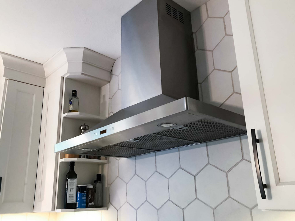 Foto di una cucina abitabile minimalista con ante in stile shaker, ante bianche, paraspruzzi bianco, paraspruzzi con piastrelle di cemento e elettrodomestici in acciaio inossidabile