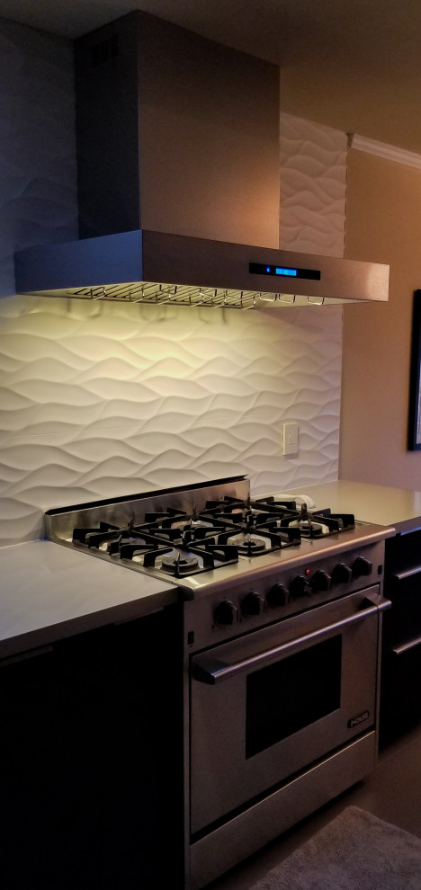 Idee per una cucina moderna con top in marmo, paraspruzzi bianco, elettrodomestici in acciaio inossidabile e top bianco