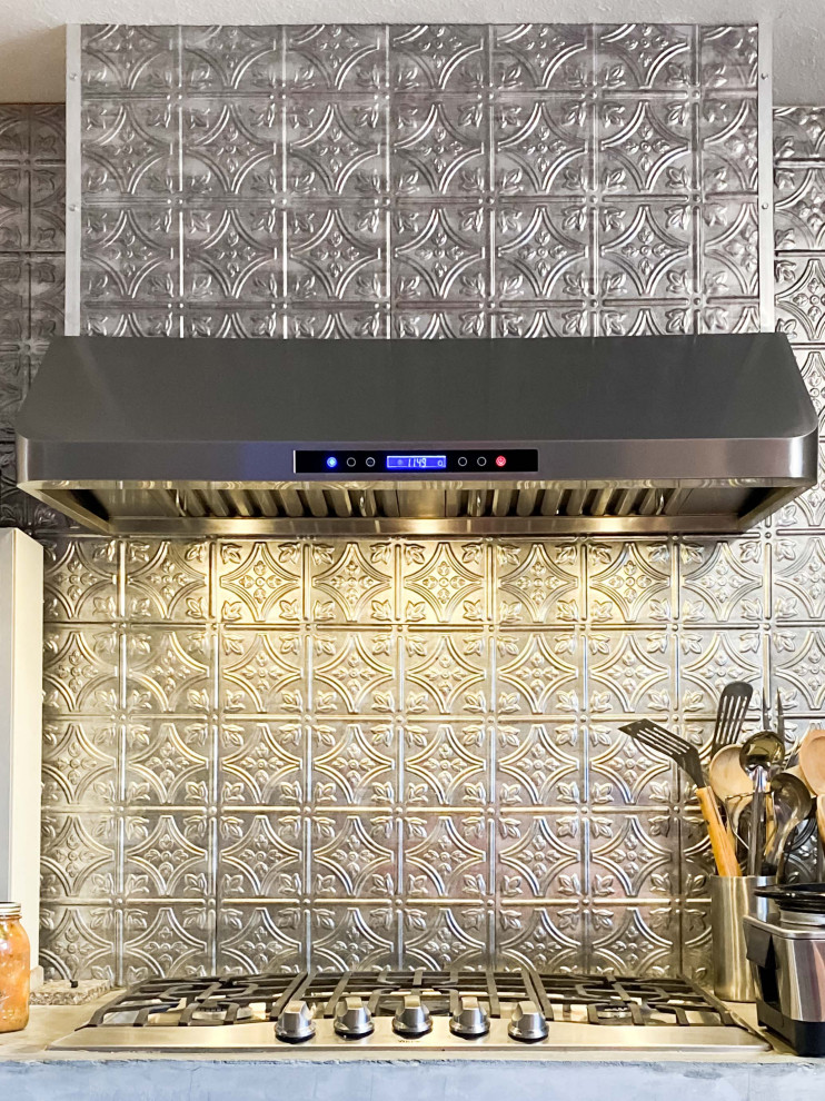 Esempio di una cucina abitabile moderna con paraspruzzi a effetto metallico e elettrodomestici in acciaio inossidabile