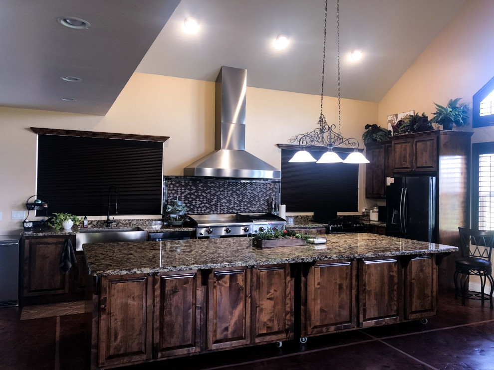 Foto på ett mellanstort funkis brun kök, med en rustik diskho, luckor med upphöjd panel, skåp i mörkt trä, granitbänkskiva, flerfärgad stänkskydd, stänkskydd i keramik, rostfria vitvaror, korkgolv, en köksö och svart golv