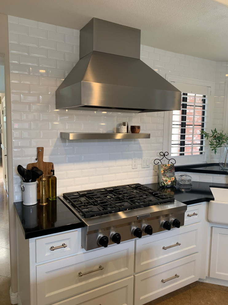 Idéer för ett mellanstort vit kök, med en rustik diskho, marmorbänkskiva, vitt stänkskydd, stänkskydd i tegel, rostfria vitvaror, cementgolv, en köksö och brunt golv